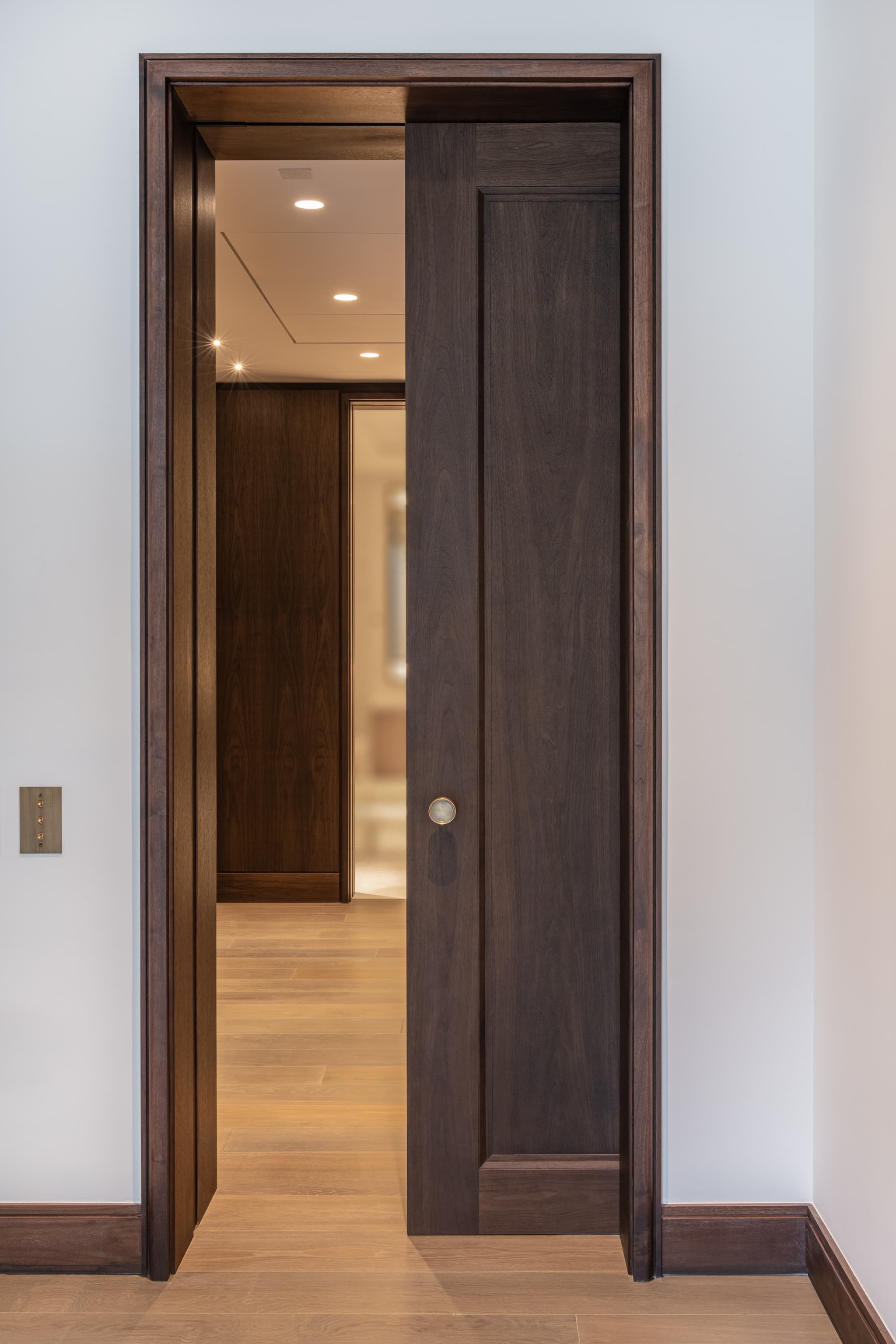 A partially closed single sliding pocket door leading to a reception area.