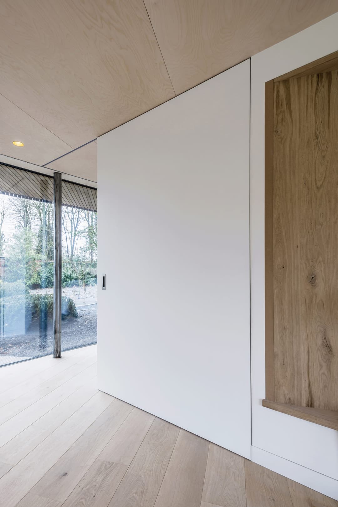 a large sliding door in a minimal white interior featuring a wide entry