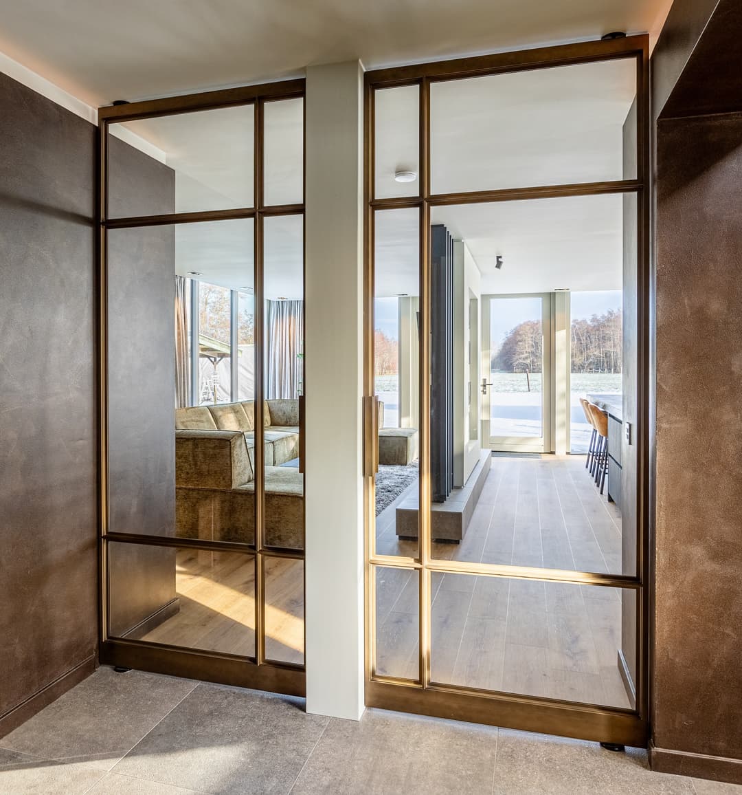 double steel glazed doors looking through to a luxurious modern living room